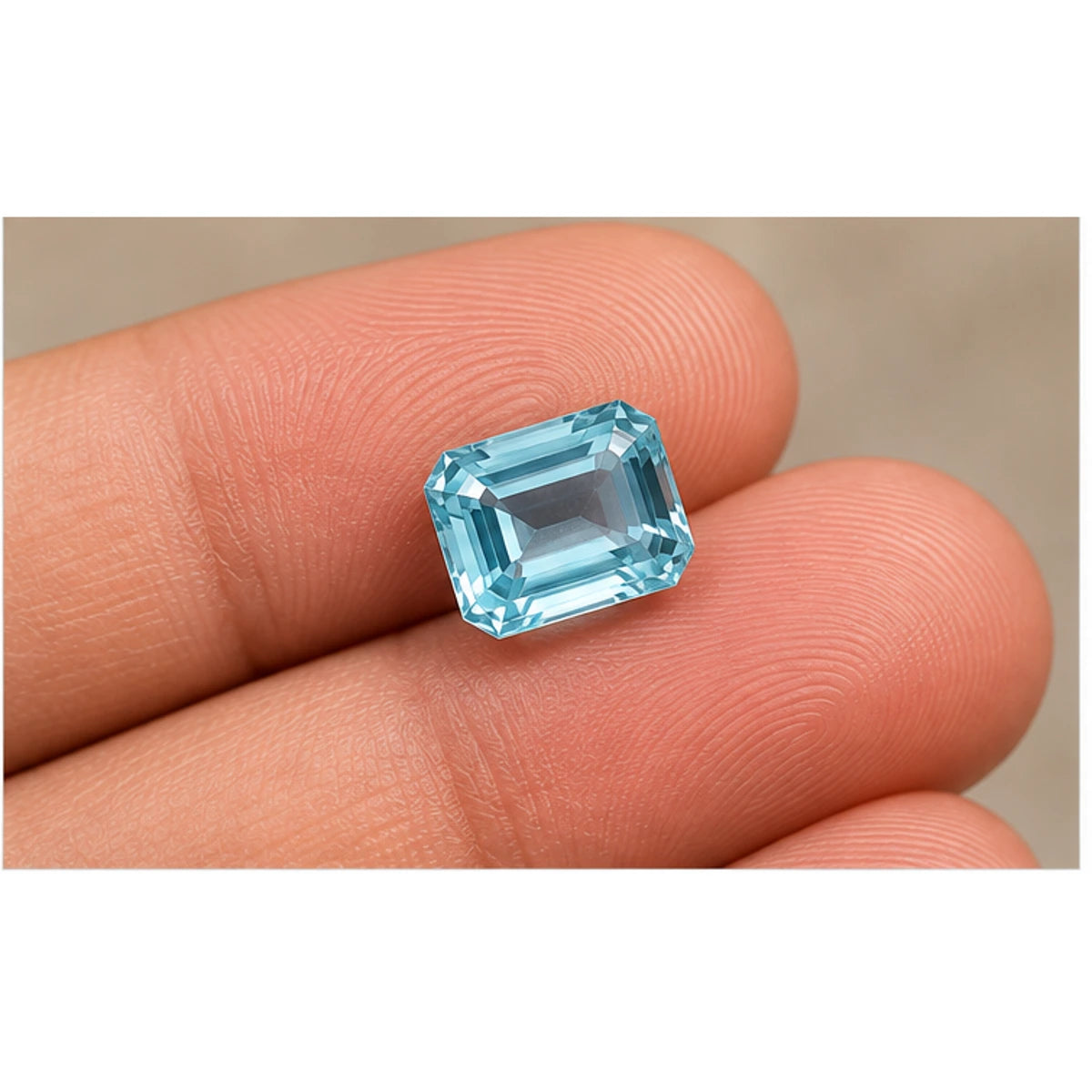 Aquamarine gemstone held on fingertips