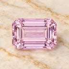 Kunzite gemstone centered on warm marble