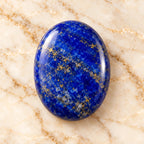 Lapis Lazuli gemstone centered on warm marble